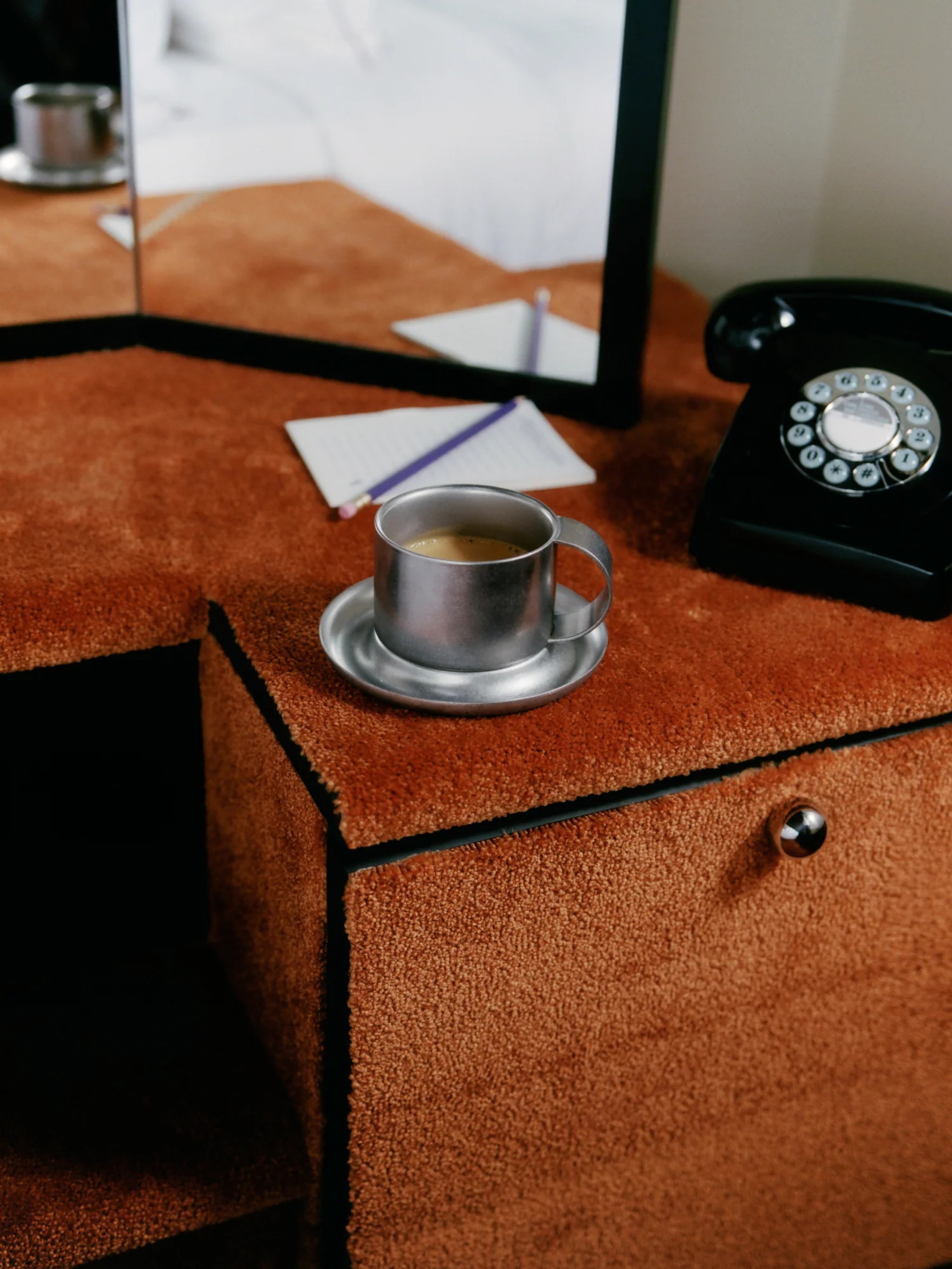 stainless steel mug on a carpeted orange vanity