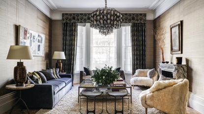 Living room with curtains, large central pendant, sofa and armchairs