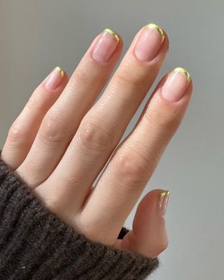 A french manicure with gold tips by Betina Goldstein