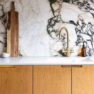 Warm wood kitchen cupboards with marble backsplash
