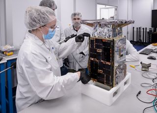 CAPSTONE technicians inspect the spacecraft at Tyvak Nano-Satellite Systems, Inc. in Irvine, California.