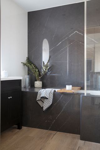 Hutchinson house: bathroom with dark grey marble effect wall and bath panelling
