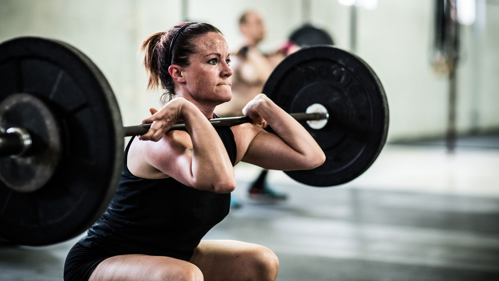 How to get stronger: Image shows woman lifting weights.