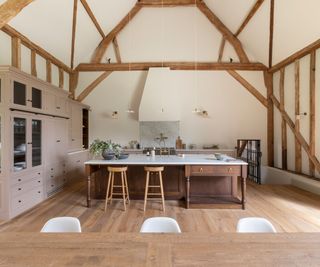 A wood and neutral kitchen with bar seating and a dining table