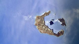 a c-shaped island with a few smaller islands against a blue sea