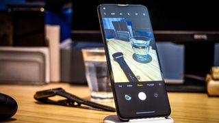 Phone on table with watch and glass of water