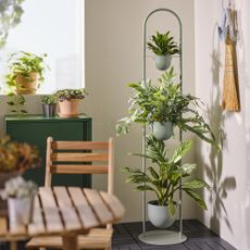 IKEA plant stand in room next to seats.