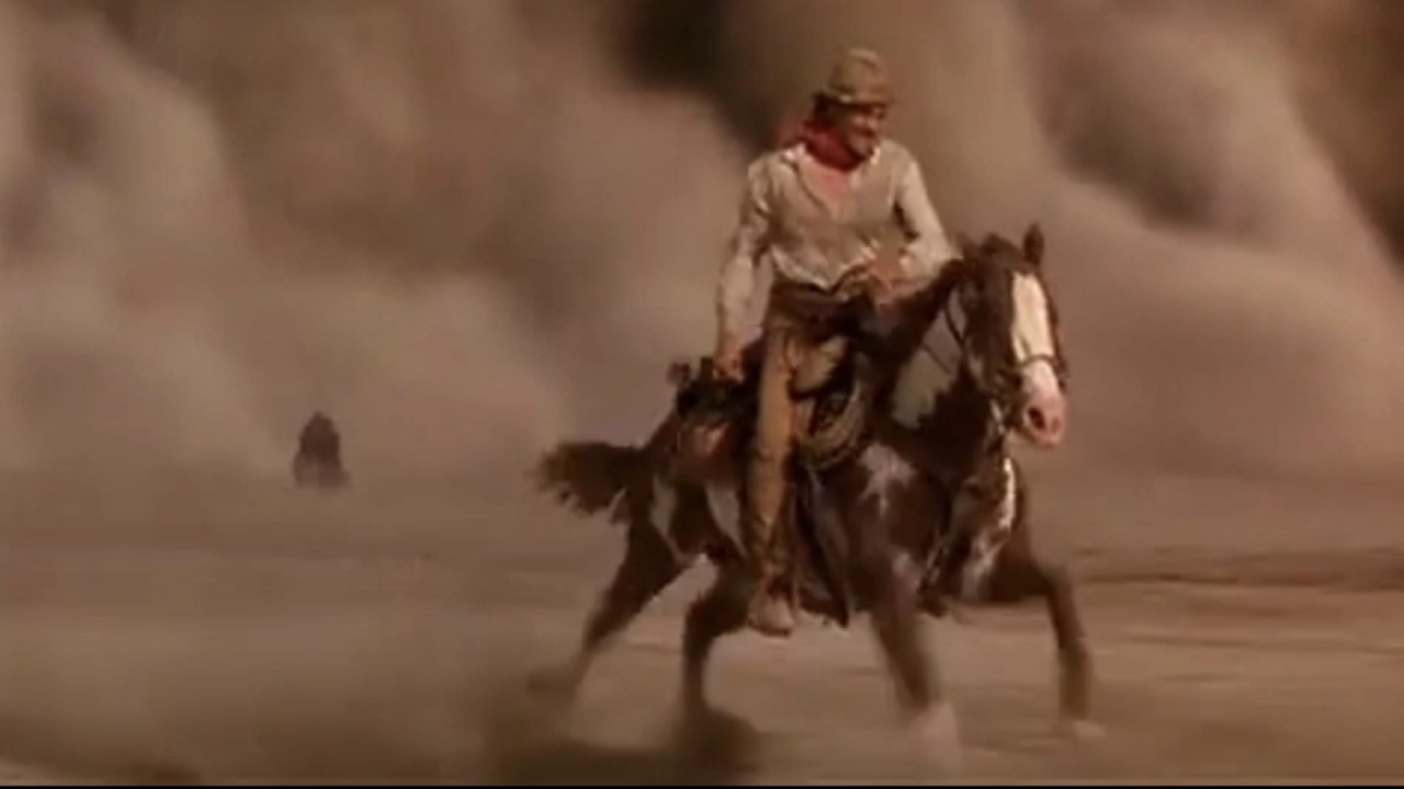 Viggo Mortensen riding Hidalgo with a sandstorm right behind him