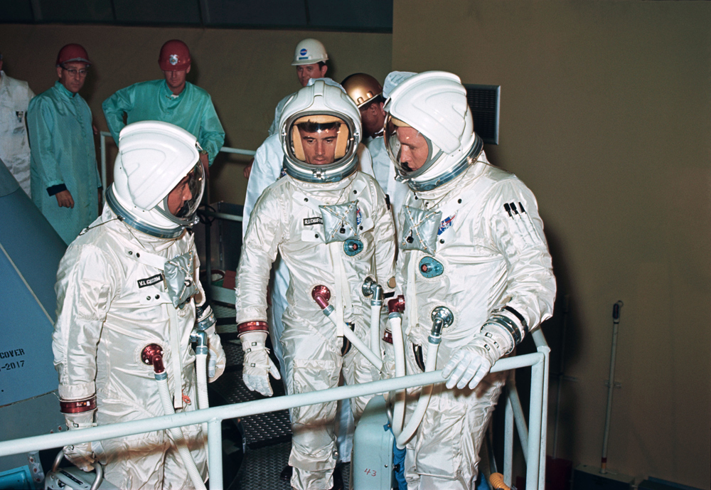 The three crew members for the Apollo-Saturn 204 (AS-204, later renamed Apollo 1) mission check out the couch installation on the Apollo Command Module (CM) at North American's Downey facility. Left to right in their pressurized space suits are astronauts