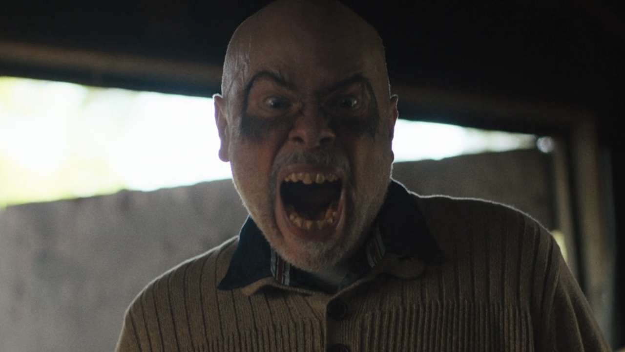 Minnie Mouse dog owner screaming at Ron with makeup aroudn eyes and sharp teeth in The Chair Company Season 1