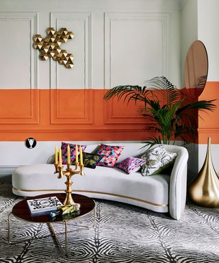 wall paneling with orange strip in a living room with zebra print carpet and retro accessories in a Hollywood Regency style