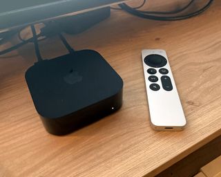 Apple TV 4K on TV unit beside remote in writer's home