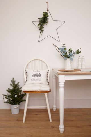 room with white cushion white table and christmas tree