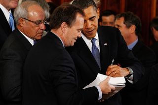 WASHINGTON - MARCH 23 President Barack Obama signs a copy of the Affordable Health Care for America Act for a member of Congress after signing the acutual bill during a ceremony in the East Room of the White House March