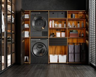 Luxurious laundry room interior with washing machine, dryer, laundry basket and folded towels in the cabinet