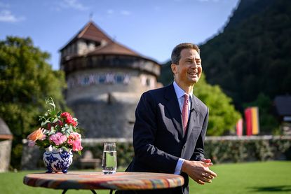 Liechtenstein's Hereditary Prince Alois reacts with the Vaduz Castle as background