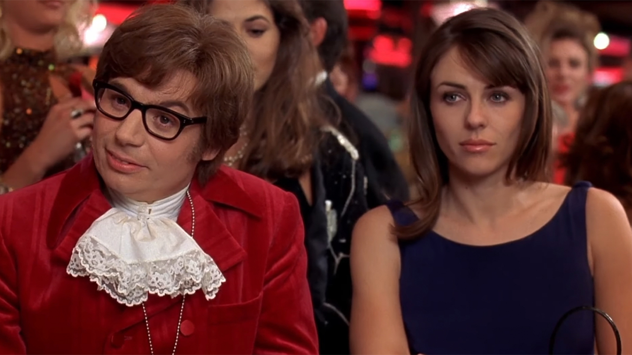 Mike Myers as Austin Powers sitting next to Elizabeth Hurley