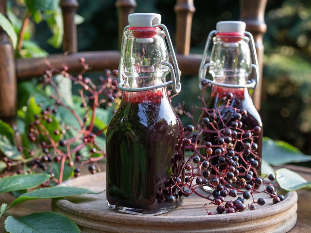 Two Syrup Bottles On A Table With Berries