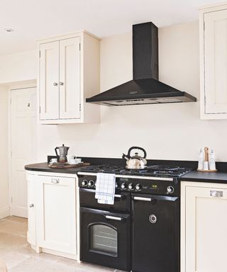 White shaker style kitchen with black range cooker and hood.