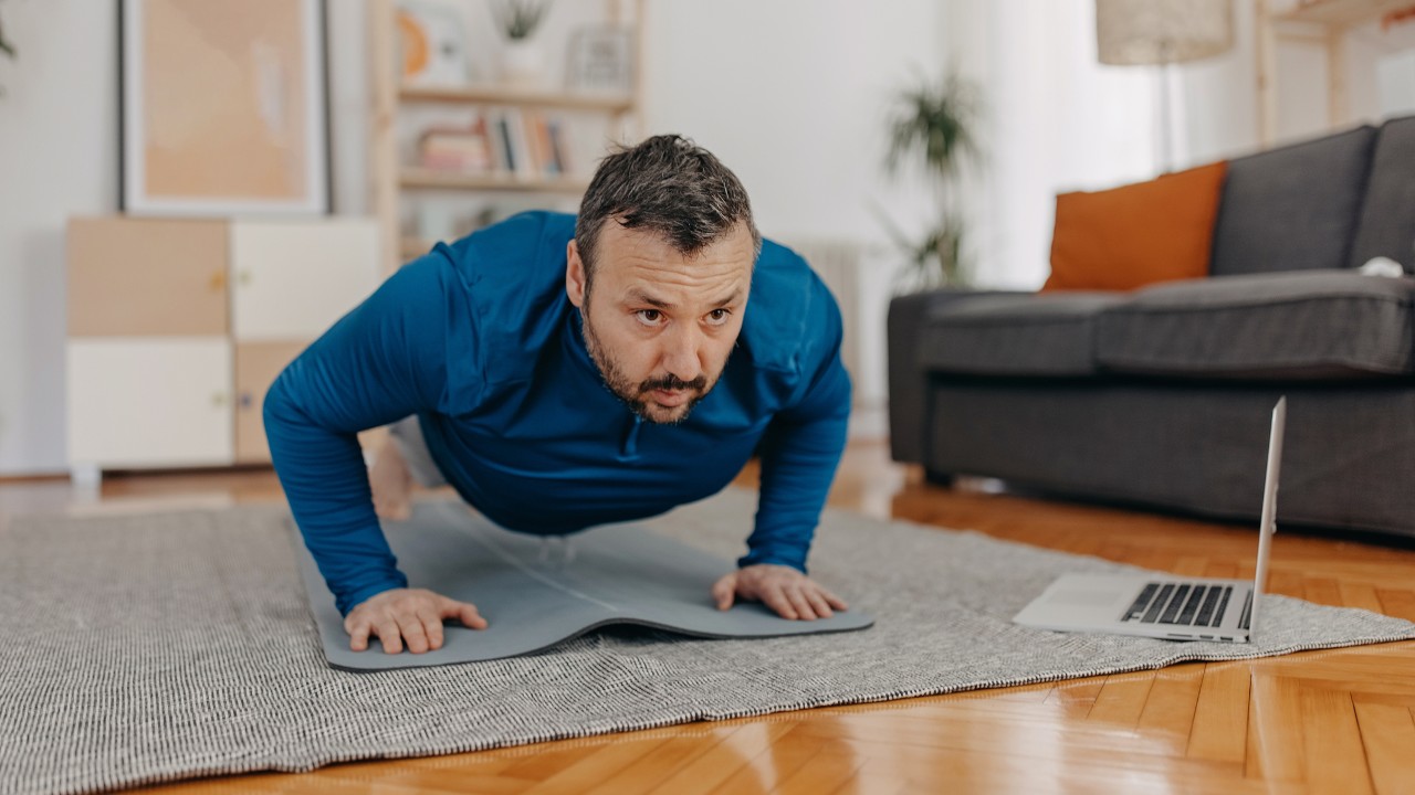 A man performs a press-up at home