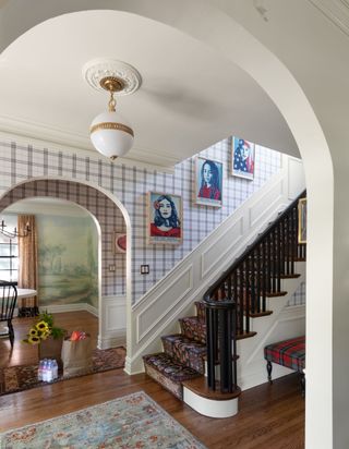 A staircase with half wallpaper and half paneling