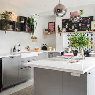 grey kitchen with crate shelves and pink pendants