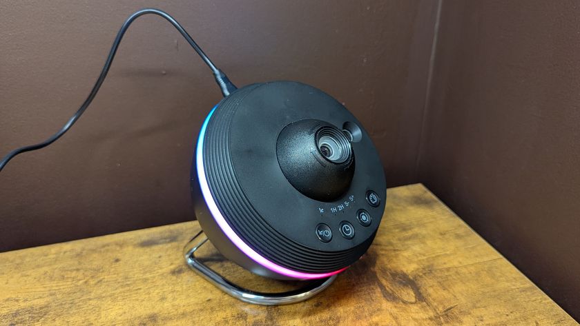 Ainael Meteor and Galaxy Projector on a woode table against a brown wall