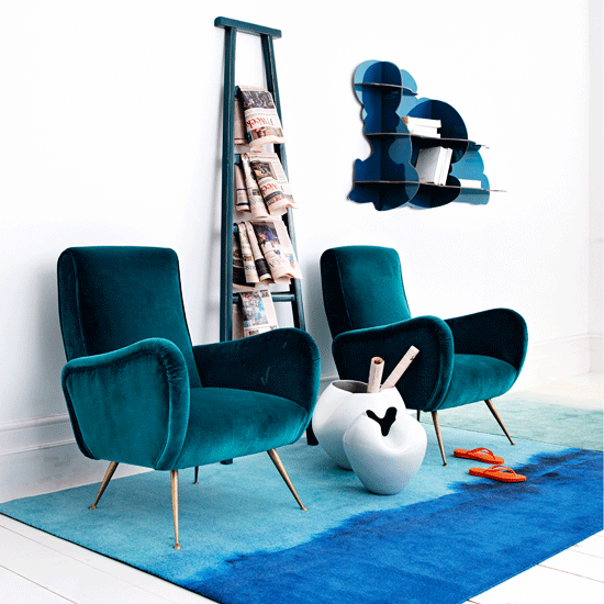 room with white wall and blue velvet sofa chair