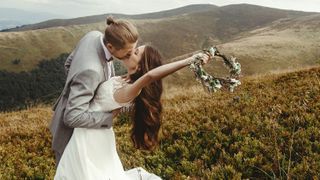 groom kissing gorgeous bride on a mountain