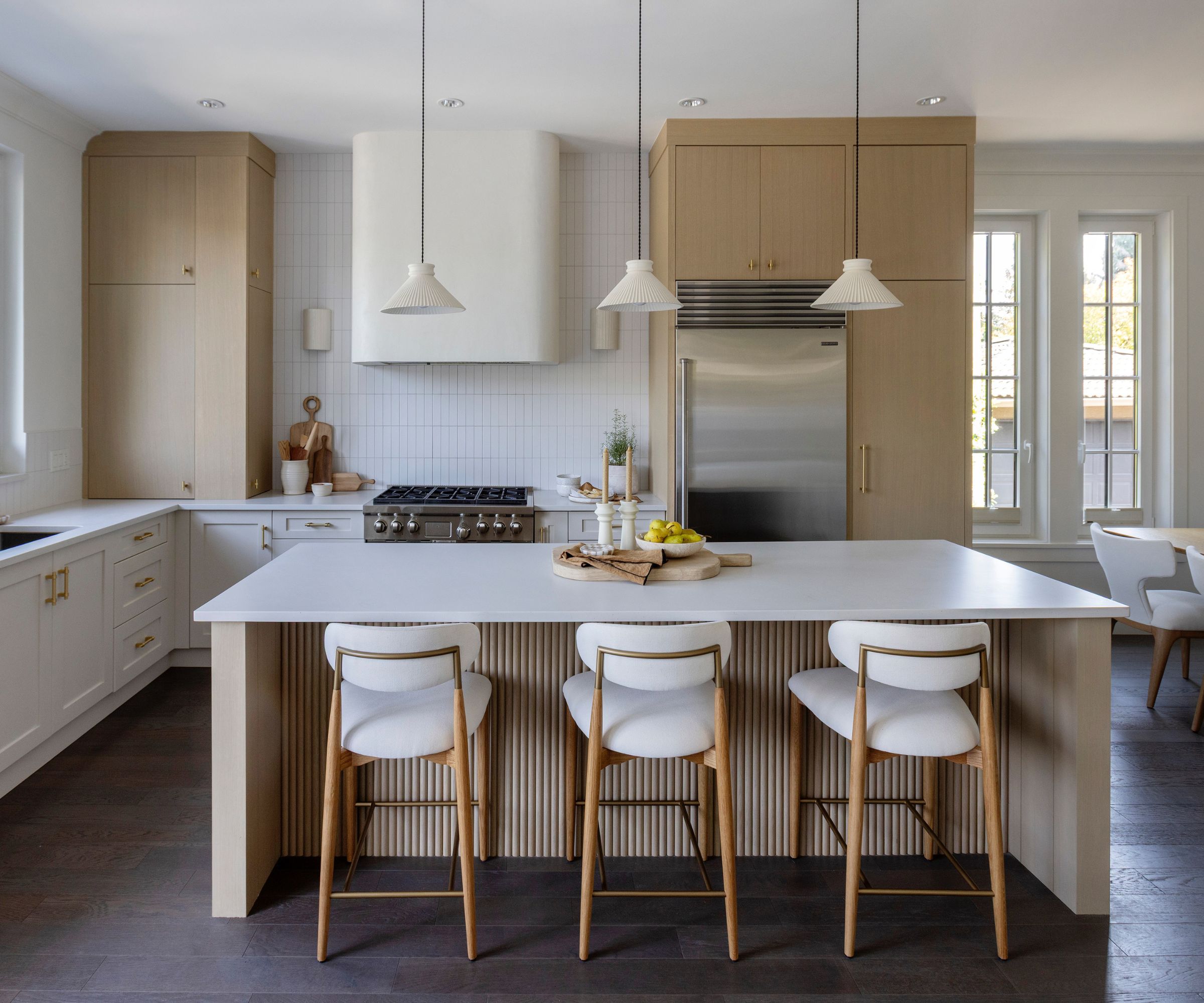 A wood and white kitchen with a curved range hood
