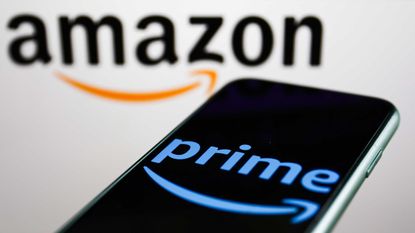Amazon Prime logo displayed on a phone screen and Amazon logo displayed on a screen in the background are seen in this illustration photo