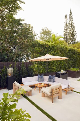 A backyard with L-shaped seating area and pre-fab bar to the side