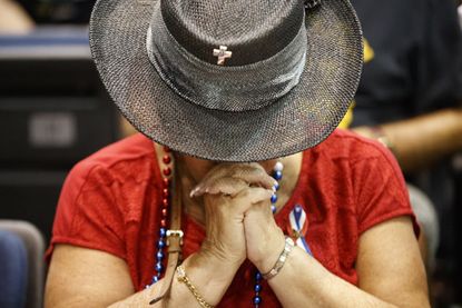 A Trump supporter prays.
