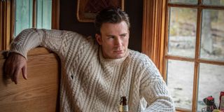 Ransom Drysdale (Chris Evans) wears a now-infamous cable knit sweater while leaning back in a booth
