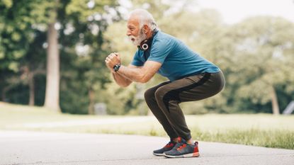 Man in park performing squat exercise