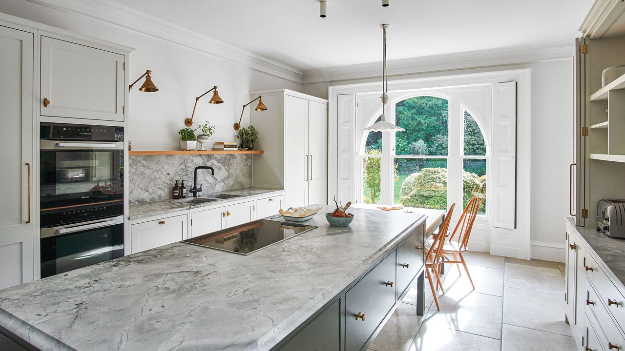 Large kitchen with marble topped island and units in white and blue