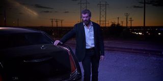 Hugh Jackman as Wolverine next to limo in Logan