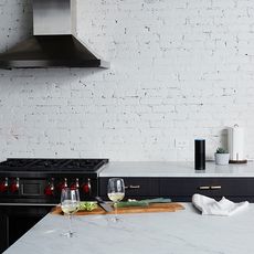 kitchen with white brick wall chimney gas and wine glasses