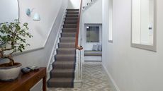 neutral entryway with tile, side table and stairway