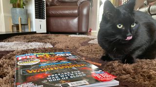luna the black cat in front of a PC Gamer magazine