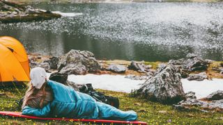 best sleeping bag: A sleeping bag positioned near a mountain lake