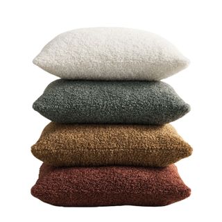 stack of four fuzzy decorative pillows