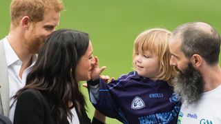 Meghan Markle playing with a child