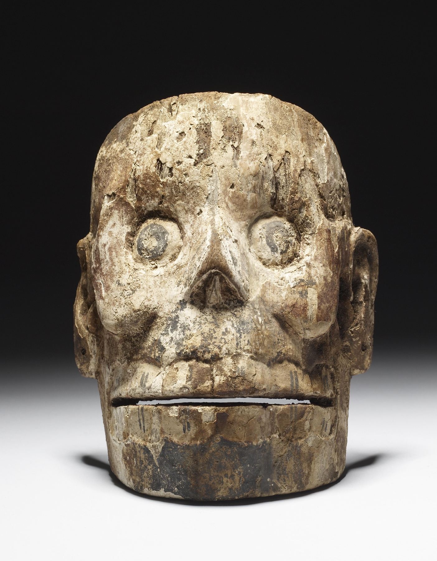front aspect of a wood mask carved like a skull from the Aztec culture