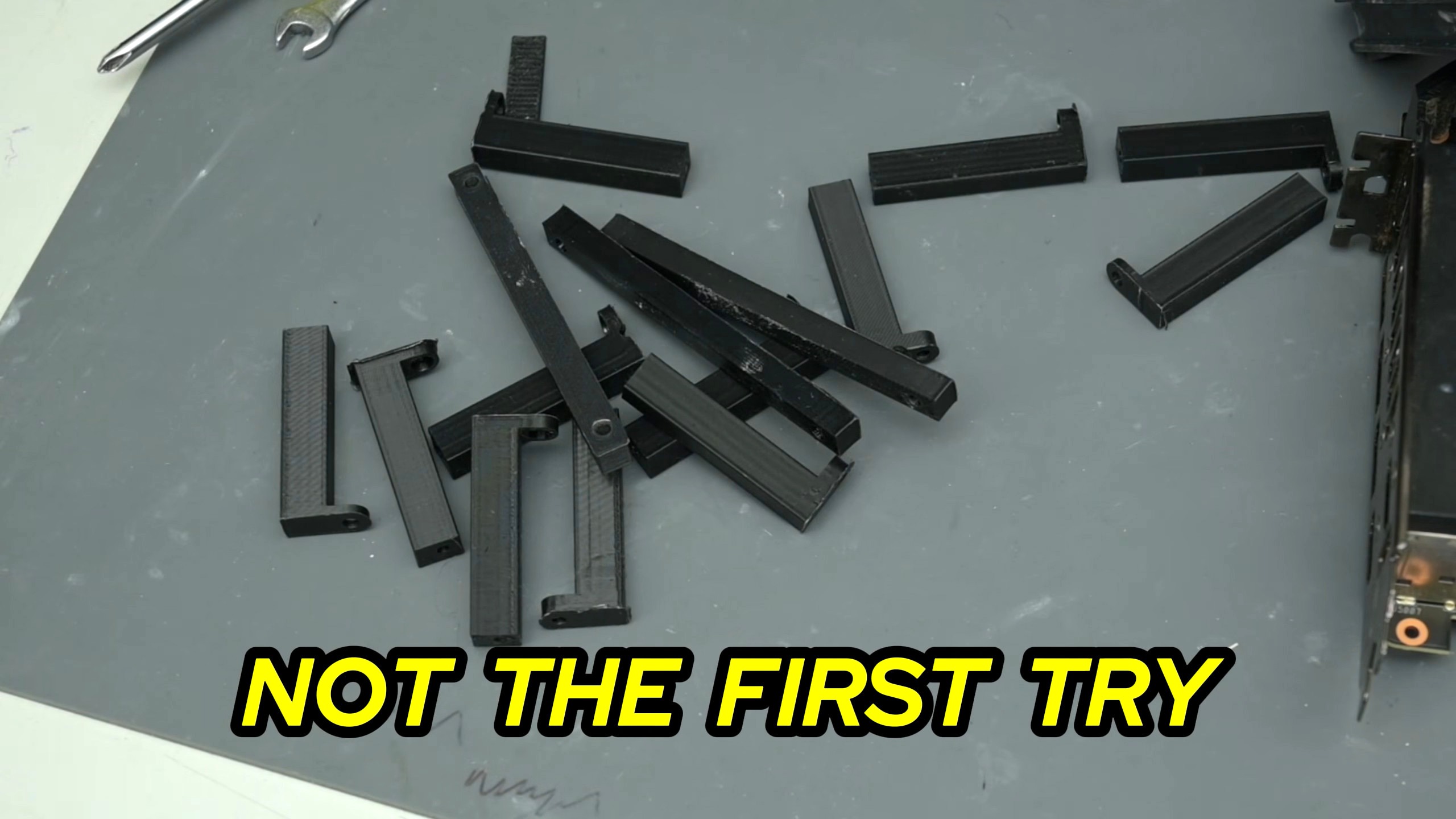 لقطة شاشة من فيديو Trashbench تظهر كومة ضخمة من الأقواس المطبوعة ثلاثية الأبعاد في محاولته تصنيع نظام تركيب للمبرد السائل WS360.