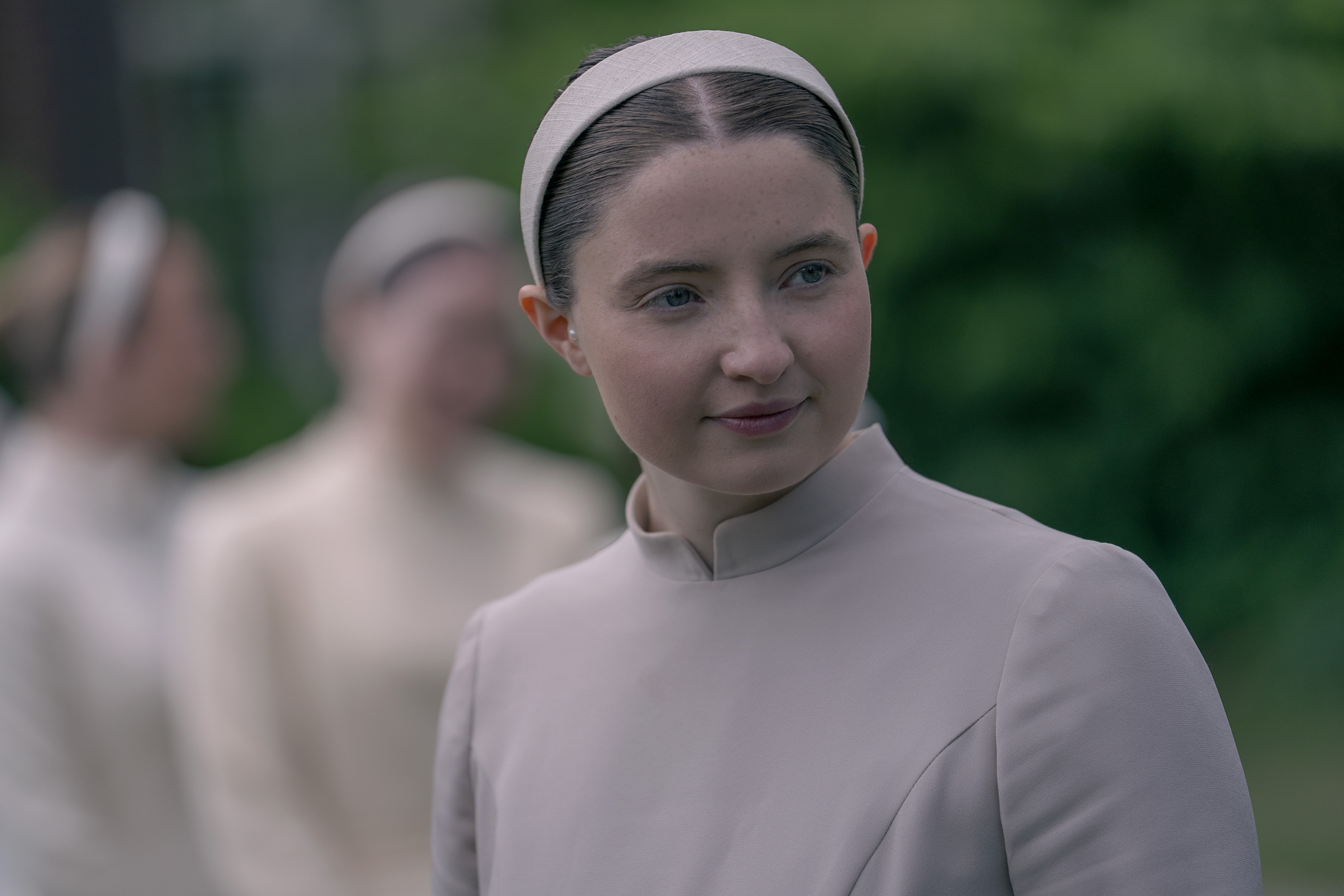 Lucy Halliday as Daisy wearing a white pearl girl ensemble and headband in 'The Testaments.'
