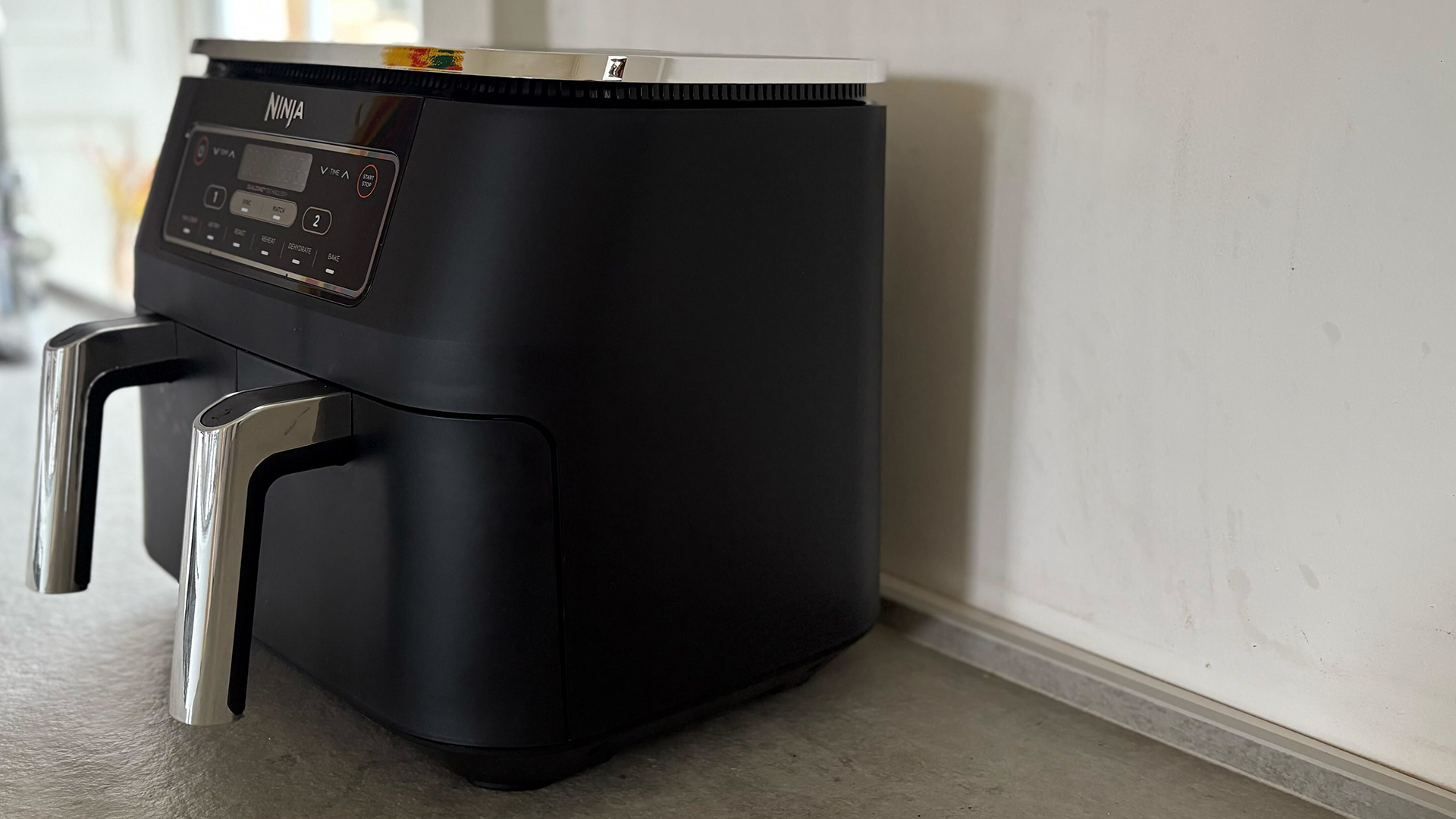 Black dual drawer air fryer on a kitchen countertop against as wall to show one of the worst places to put an air fryer