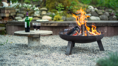 Best fire pit 2022: image depicts fire pit and table with red wine.