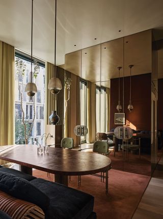 a dining room with a bronze colored mirrored walls