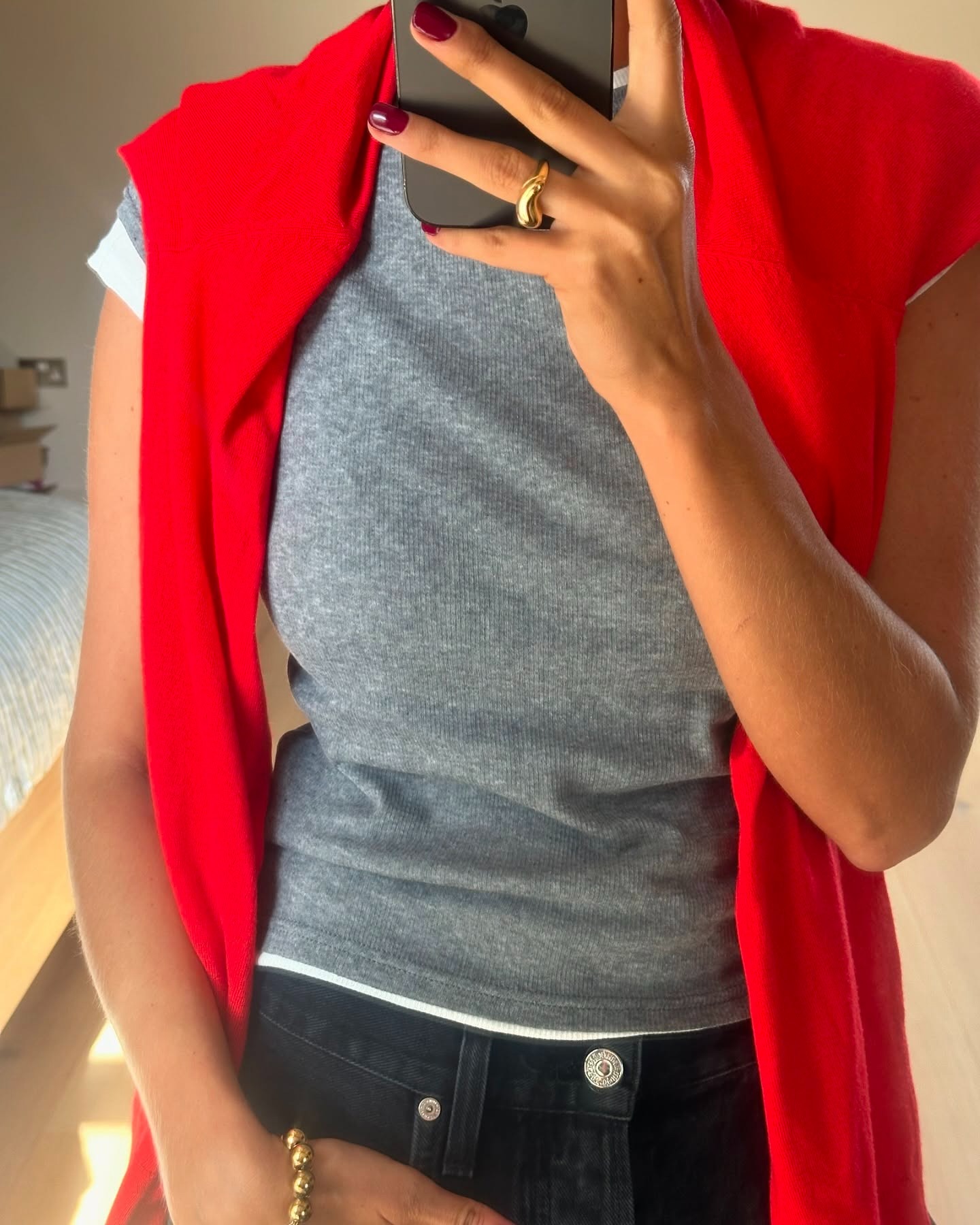 Influencer Marianne Smyth wears black barrel jeans with double tee shirts and red sweater.